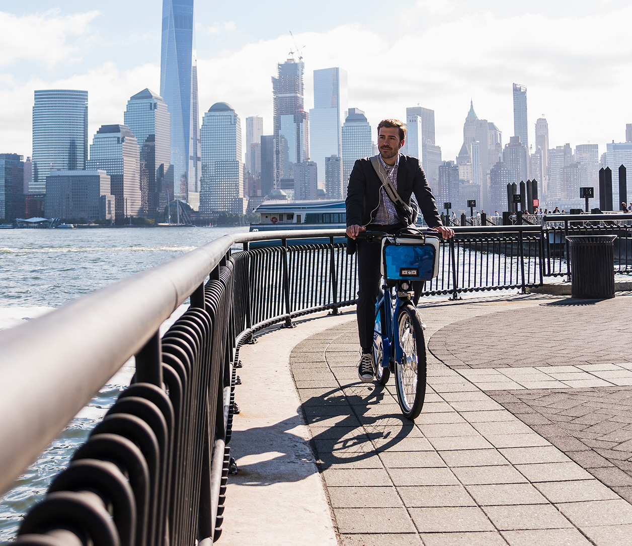 man riding bike with a city background